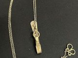 a close up of a necklace with a key on a black surface