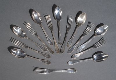 un grand nombre de cuillères et de fourchettes en argent disposées en cercle