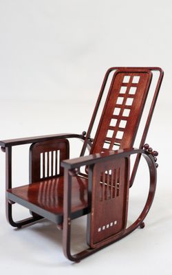 un fauteuil à bascule en bois avec une assise en bois sur fond blanc