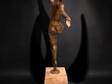 sculpture of a woman on a wooden block in a dark room