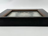 an old picture frame with a picture in it on a stand