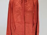an orange jacket on a mannequin stand against a white wall