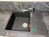 a black sink with a faucet in the middle of it