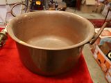 a large metal pot sitting on a red table