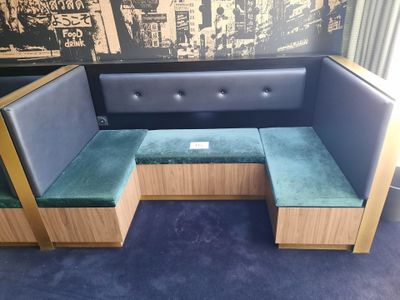 une banquette avec un siège vert et un coussin bleu