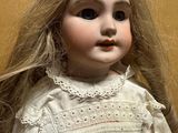 a close up of a doll with long blonde hair