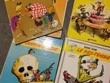 four children ' s books are sitting on a table in a room