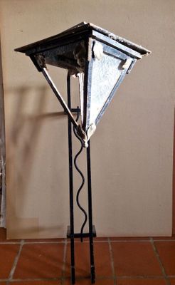 a metal lamp that is on a stand on the floor