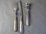 three forks and a knife sitting on a table