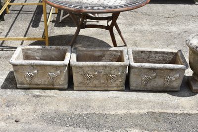 a table with four planters and a table with a bird on it