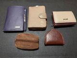 quatre modèles différents de portefeuilles en cuir posés sur une table