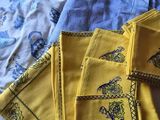 des serviettes jaunes ornées de motifs bleus et jaunes, posées sur un lit