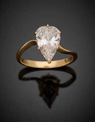une bague sertie d'un diamant en forme de poire sur un fond noir