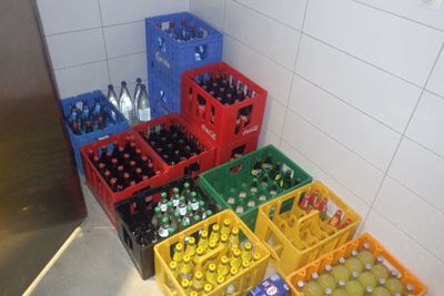 de nombreuses caisses de bouteilles de soda dans un coin de la pièce