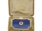 a small box with a blue and white broochle inside of it