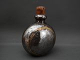 an image of a silver vase with a wooden top