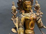 bronze statue of a person sitting on a horse with a bird on its back