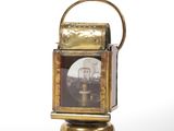 an old fashioned brass clock with a glass dome on top of it