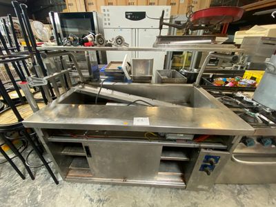 de nombreuses tables de travail en acier inoxydable dans un entrepôt