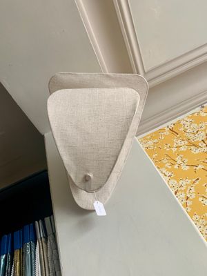 un petit objet en forme de triangle posé sur une table à côté d'une bibliothèque