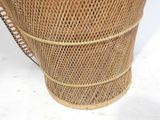 a wicker basket with a handle on a white surface
