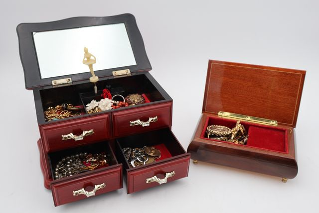 Deux coffrets à musique en bois garnis de bijoux fantaisie, l’un ...