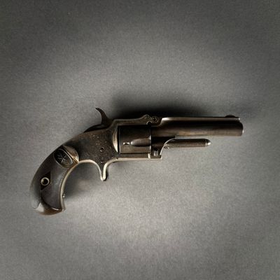 an old gun is laying on a table with a gray background