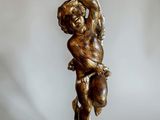 bronze statue of a boy holding a vase on his head
