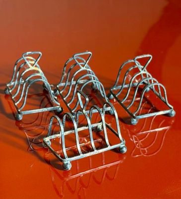four pieces of silver wire on a red surface