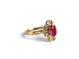 an image of a gold ring with a ruby stone in the center