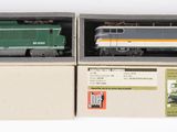 deux boîtes contenant un train miniature, posées sur une surface blanche