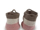 pair of pink and white crocheted baby booties on a white background
