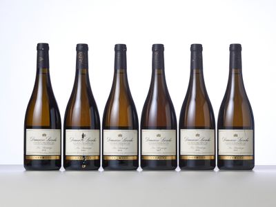 six bottles of white wine lined up on a table
