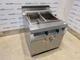 a silver fryer sitting on top of a counter next to a wall