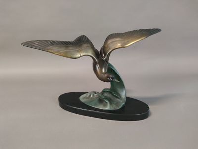 statue of a bird on a black base on a white background