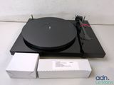 an image of a black turntable with a box of white boxes on it