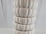 plusieurs vases blancs empilés les uns sur les autres sur une table