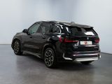 the rear end of a black bmw suv parked in a room