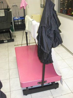 un tapis rose posé par terre, sur lequel est accroché un manteau noir