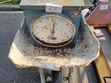 une vieille horloge posée sur une brouette dans un parking