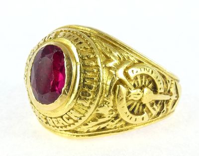 a close up of a gold ring with a red stone in it