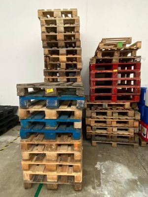 plusieurs palettes en bois empilées les unes sur les autres dans un entrepôt