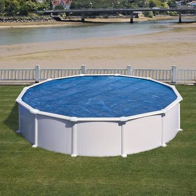 une piscine au milieu d'une pelouse, avec un pont en arrière-plan