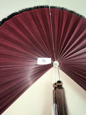 une femme tenant un parapluie rouge sur lequel est accrochée une étiquette