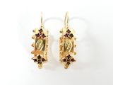 pair of gold earrings with garnets and garnets on them