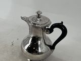 silver plated coffee pot with a black handle