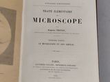 an open book with a black and white image of a microscope on it