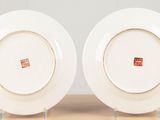 two white plates sitting on top of a wooden table