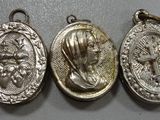 five silver medals are hanging on a wall in a row