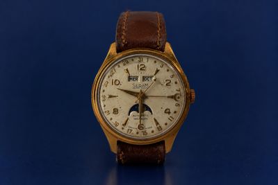 a watch that is sitting on a blue surface